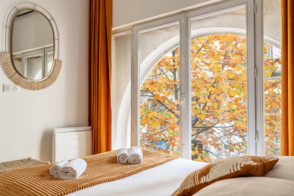Bedroom 1 — arched window, autumn trees, rolled towels
